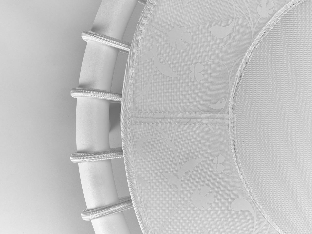 Standpolin in Weiß im Detail mit floralem Muster, heller Sprungfläche, weißem Rahmen und Seilringen für aktives Stehen, Balance und ergonomische Bewegung.