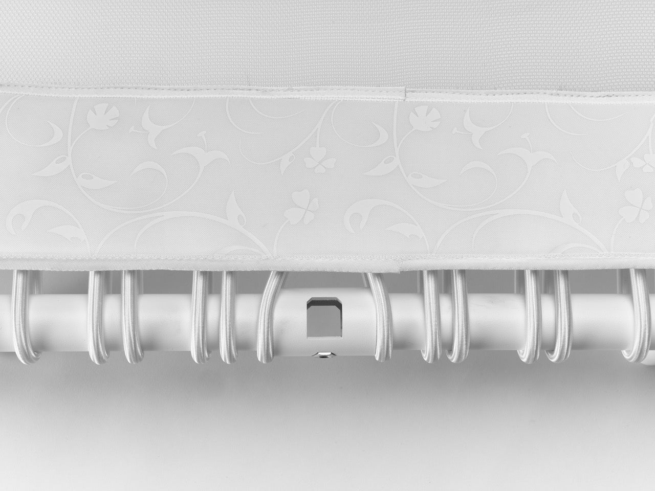 Standpolin in Weiß im Detail mit floraler Musterung, heller Sprungfläche, weißem Rahmen und elastischen Seilringen für aktives Stehen und Balance.