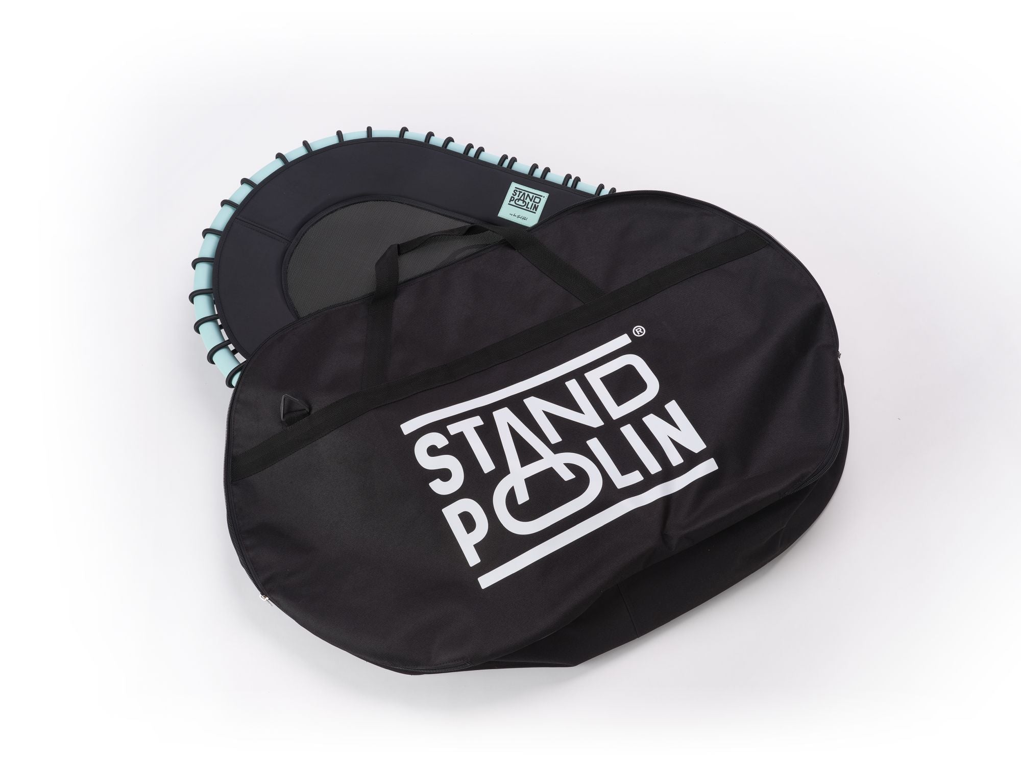 Standpolin mit Aqua Rahmen und sichtbarem Standpolin Logo liegt neben einer großen schwarzen Standpolin Tragetasche mit weißem Logo auf weißem Hintergrund.