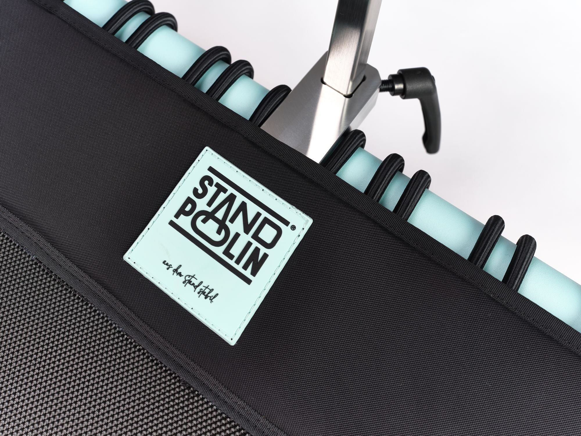Detailaufnahme vom Standpolin mit Aqua Rahmen, schwarzer Sprungfläche, Standpolin Logo und höhenverstellbarer Halterung mit Feststellhebel.