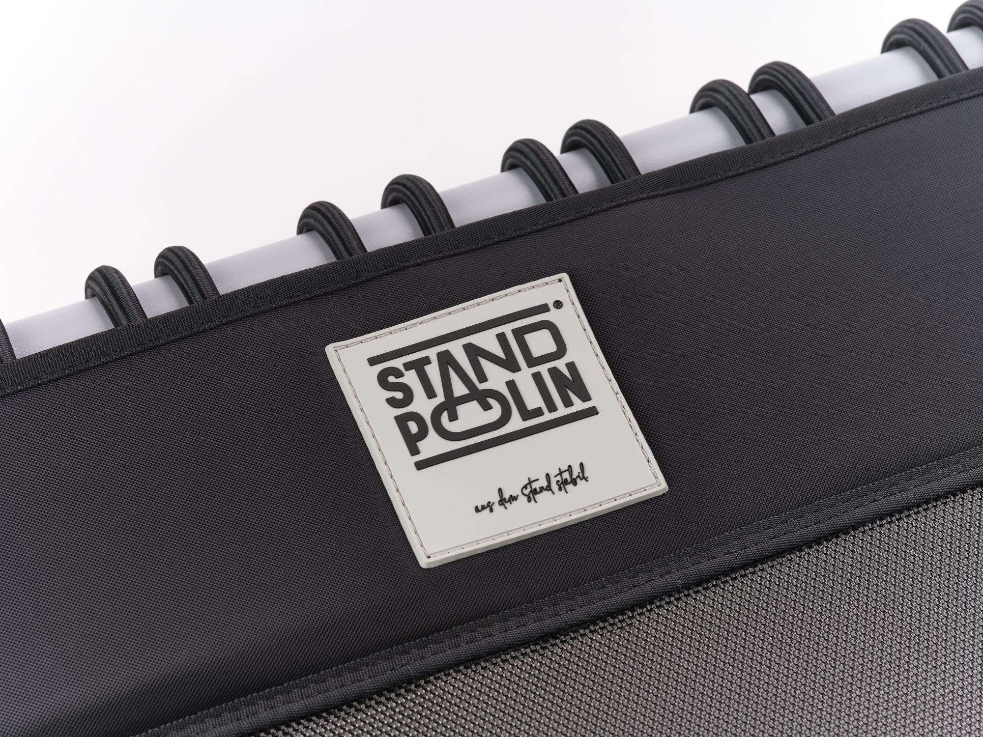 Detailaufnahme des Standpolin Logos auf schwarzem Bezug mit hellgrauem Rahmen, schwarzen Gummiseilen und hellem Studiohintergrund