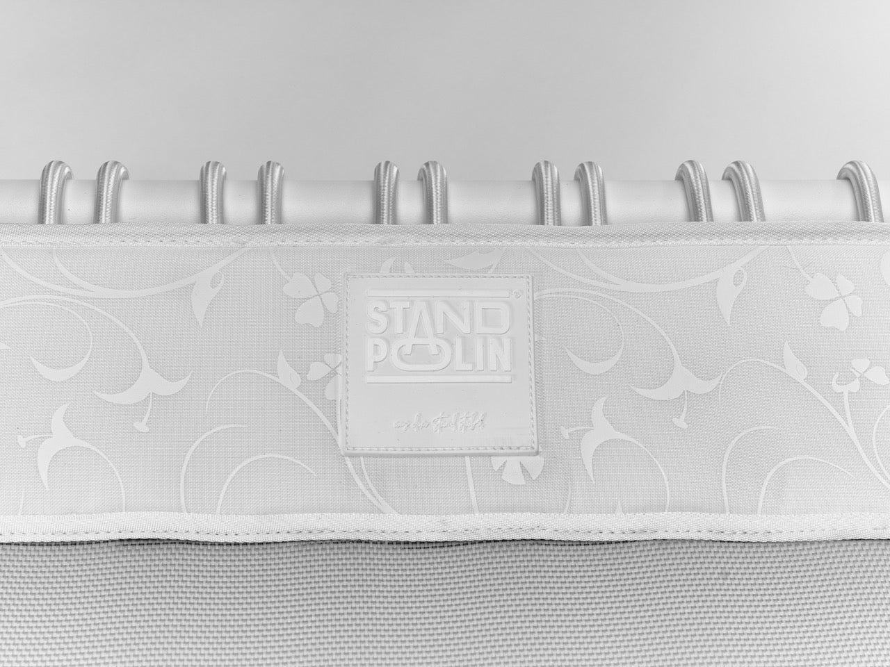 Standpolin in Weiß im Detail mit floraler Musterung, geprägtem Logo, heller Sprungfläche und weißen Seilringen für aktives Stehen und Balance.