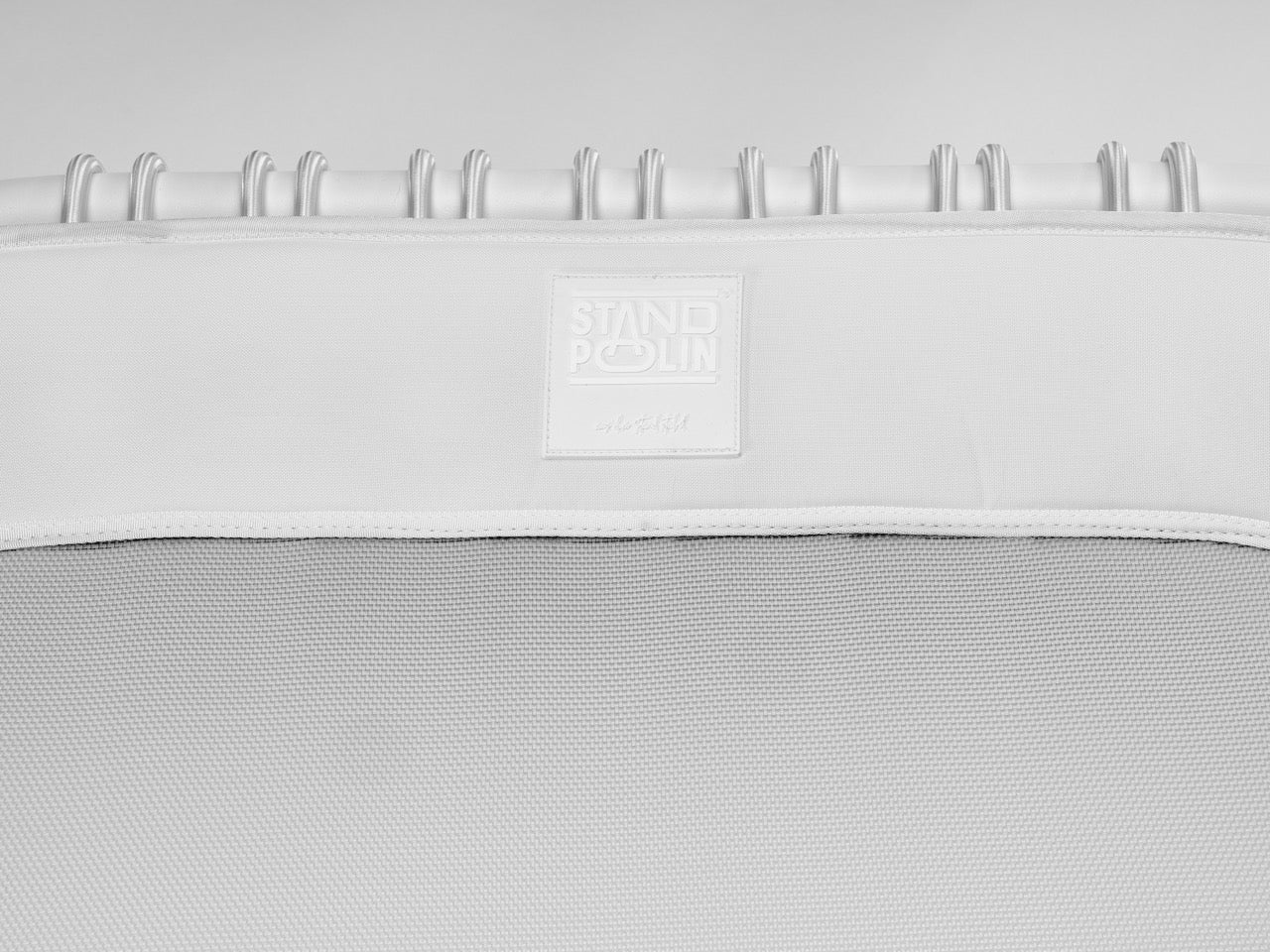 Standpolin in Weiß im Detail mit geprägtem Logo, weißem Rahmen und heller Sprungfläche für aktives Stehen, Balance und ergonomische Bewegung.