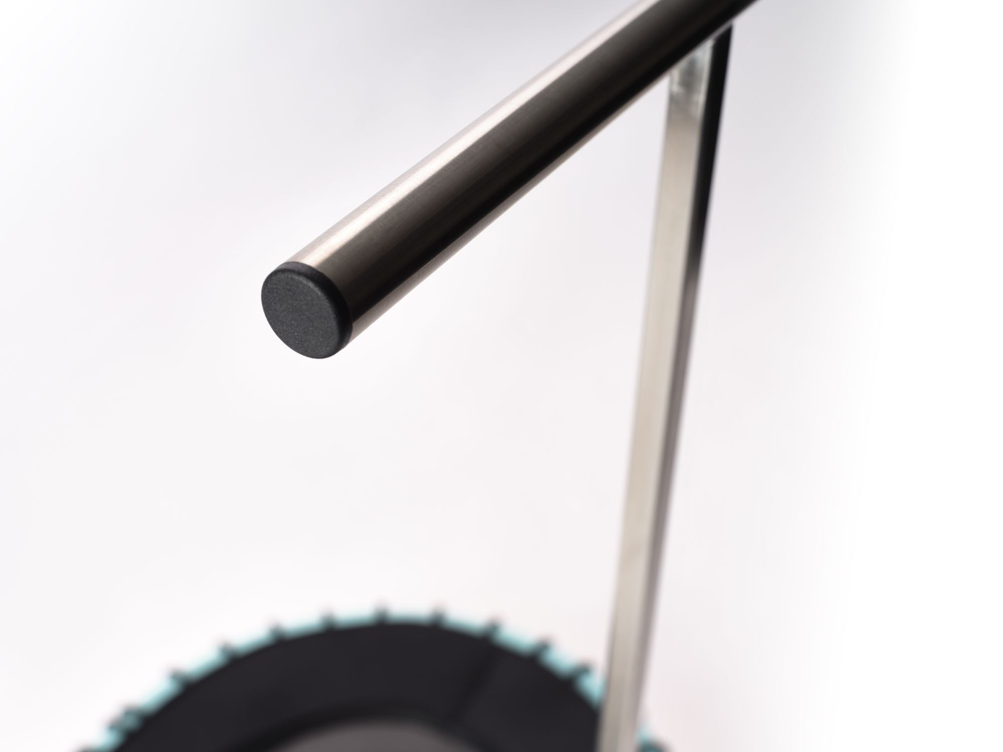 Detailaufnahme der Standpolin Haltestange mit Metallgriff, schwarzem Griffende und unscharfem Standpolin mit Aqua Rahmen im Hintergrund.