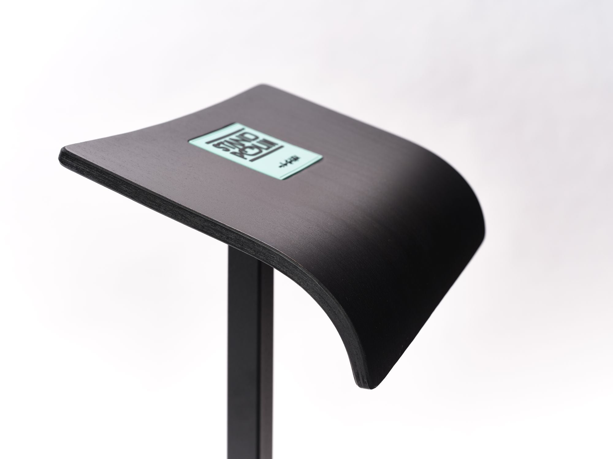 Detailaufnahme der gebogenen Standpolin Sitzfläche mit schwarzer Oberfläche, Aqua Standpolin Logo und stabilem schwarzen Standfuß auf weißem Hintergrund.